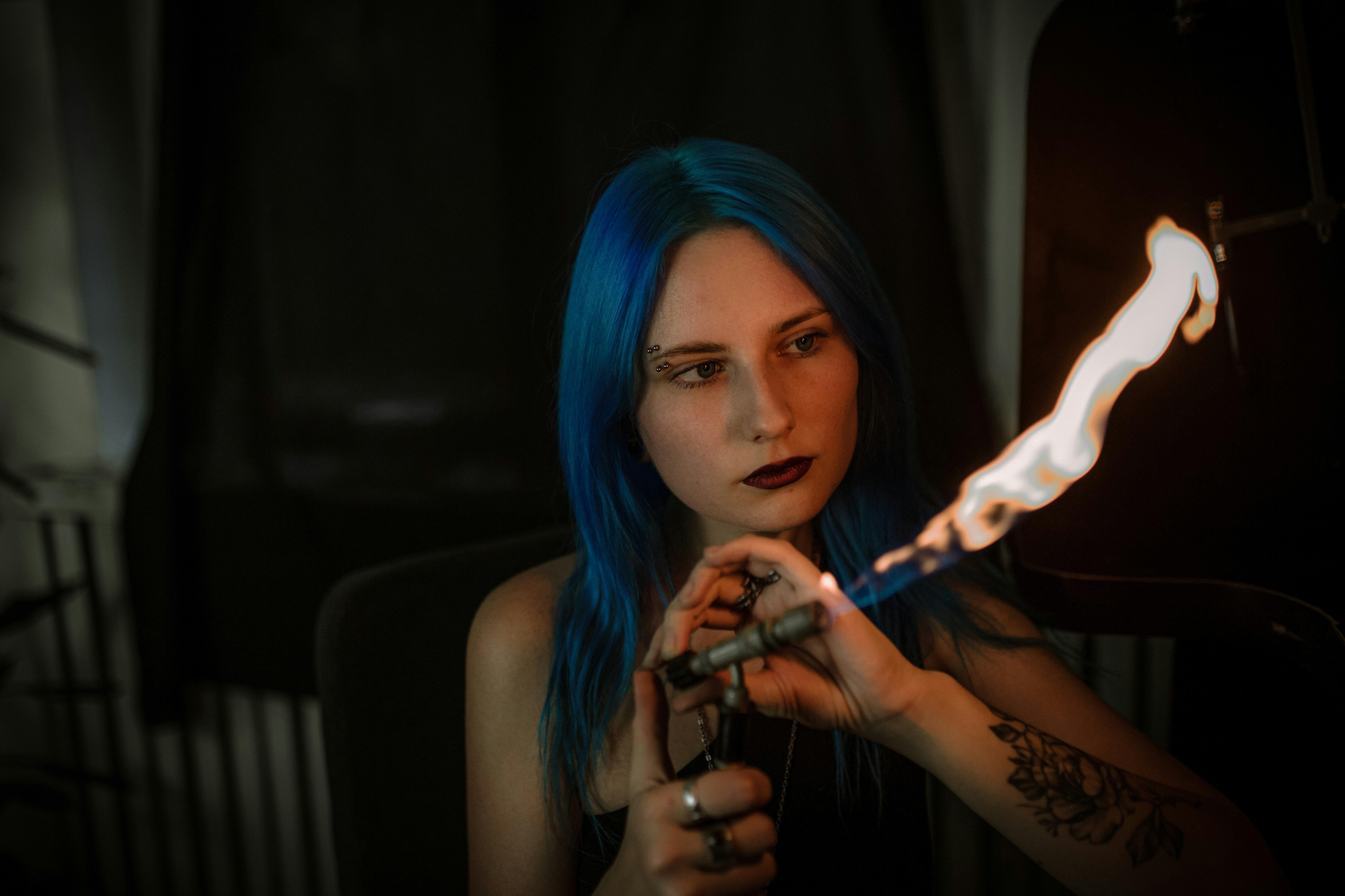 woman with blue hair holding cigarette stick